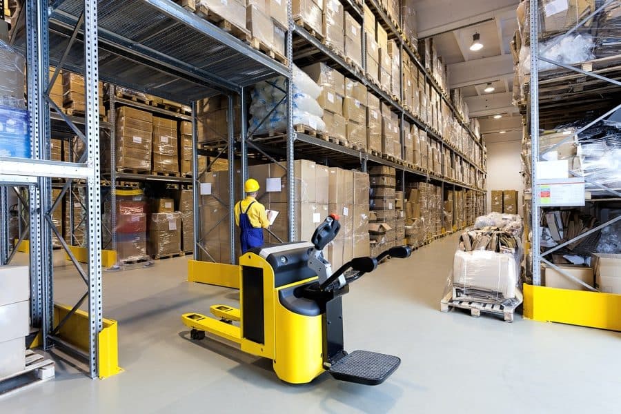 Warehouse operators moving palletised cargo with a forklift